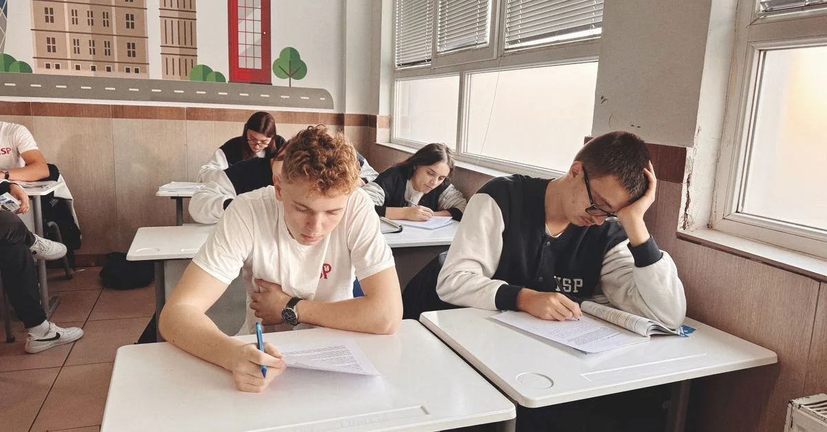 Les étudiants se sont concentrés sur leurs examens dans une salle de classe présentant des œuvres d'art murales sur le thème du Royaume-Uni.