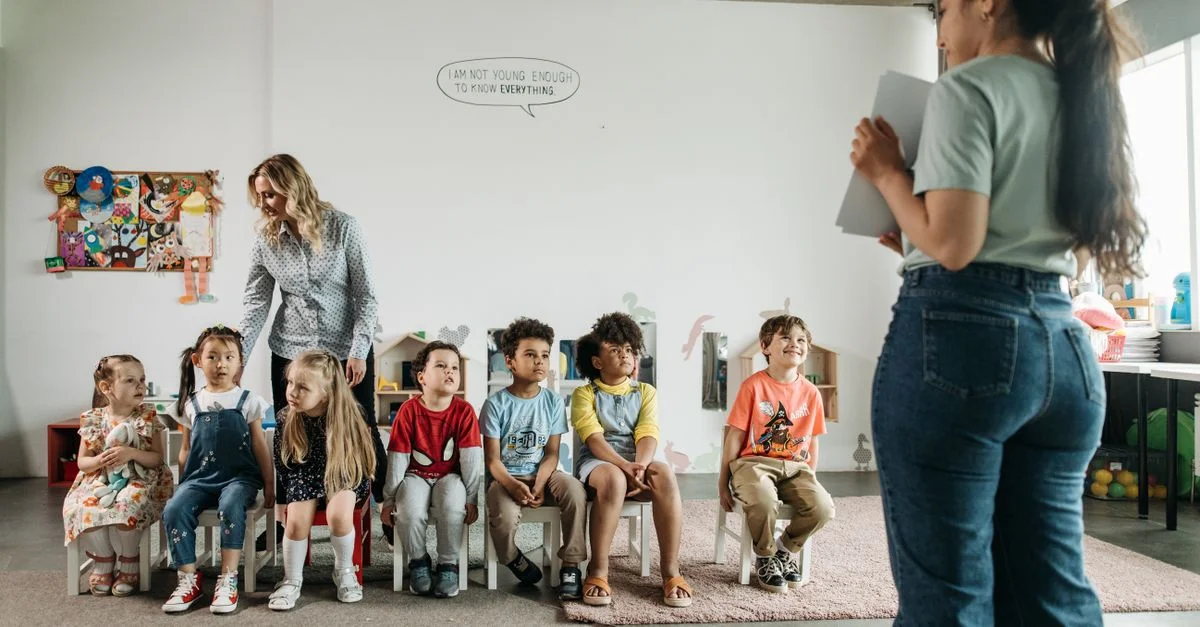 Groupe diversifié d'enfants d'âge préscolaire et d'enseignants dans un cadre de classe engageant.