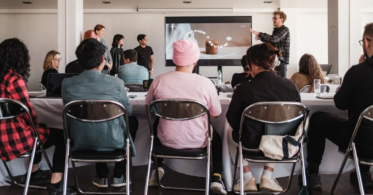 Un groupe divers engagé dans un atelier professionnel avec un écran de présentation ; cadre d'apprentissage professionnel.