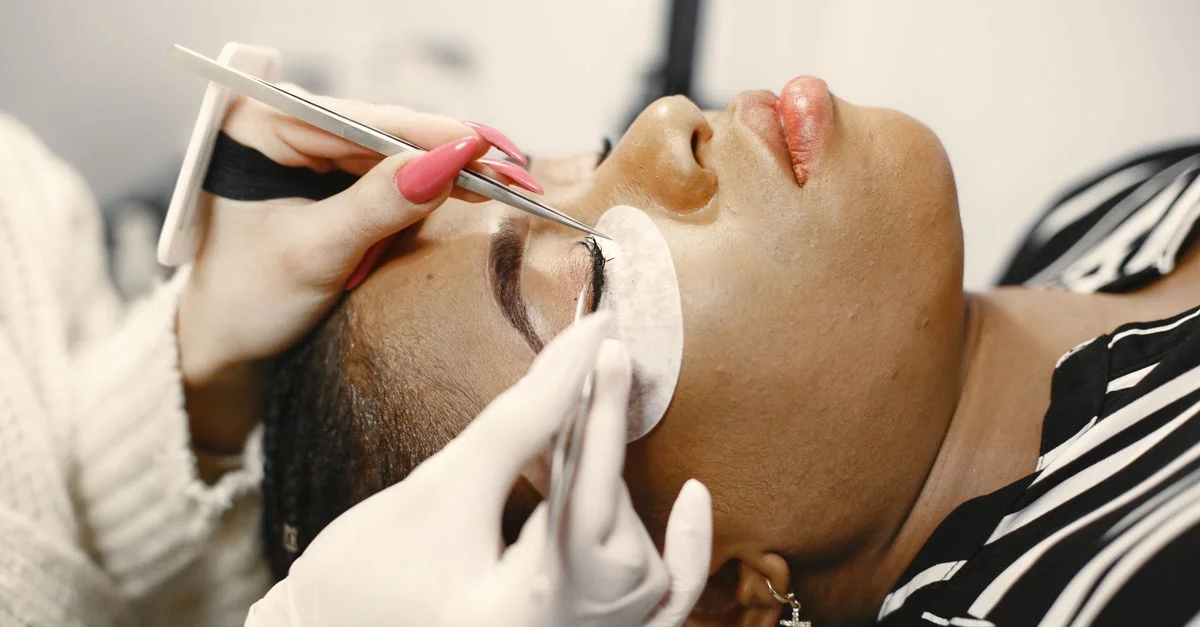 Une vue en gros plan d'une femme recevant un traitement d'extensions de cils dans un salon de beauté.