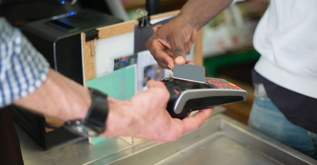 Un paiement sans contact effectué à l'aide d'un lecteur de carte au comptoir de caisse d'un magasin.