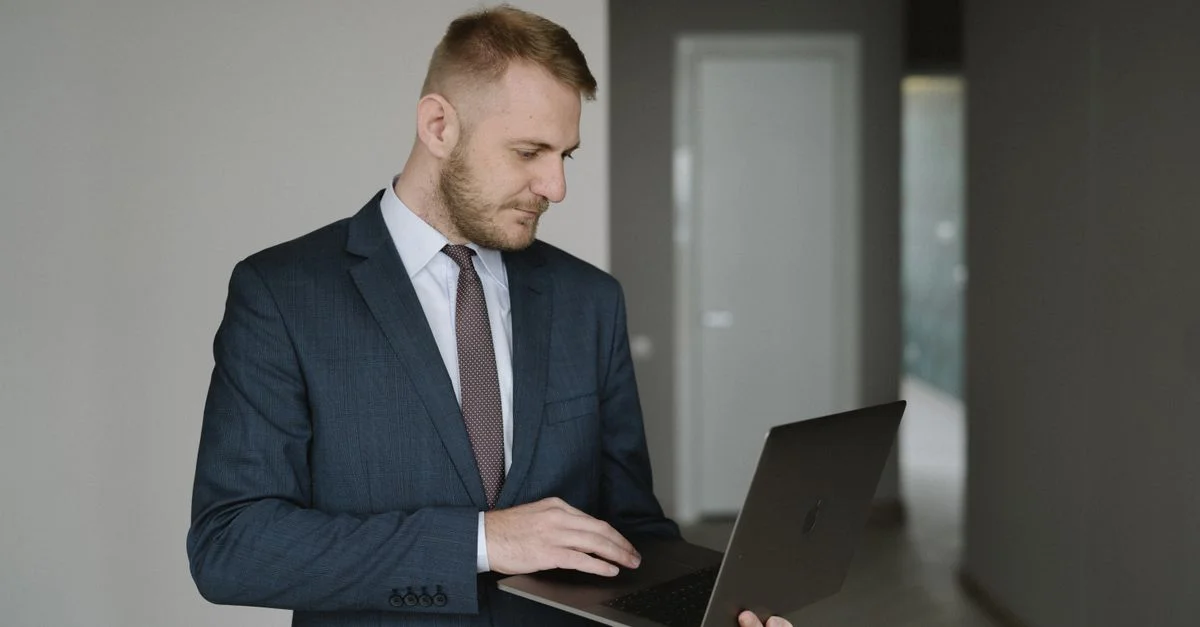 Homme d'affaires en costume travaille sur un ordinateur portable dans un bureau moderne, transmettant du professionnalisme.