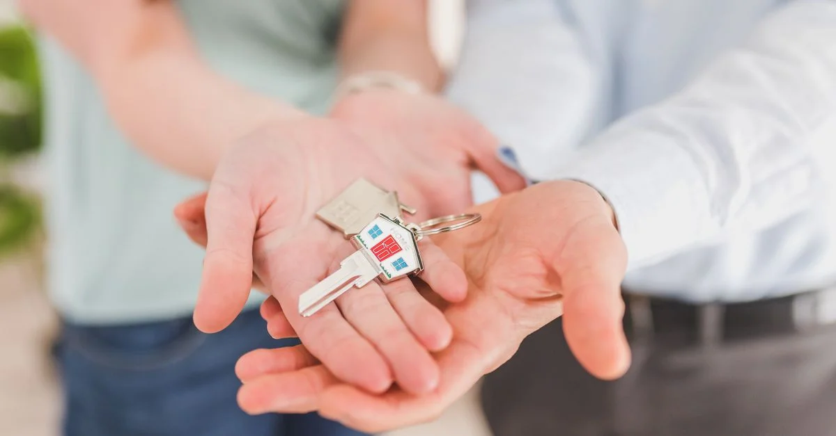 Gros plan d'un couple tenant des clés, symbolisant la propriété et l'investissement.