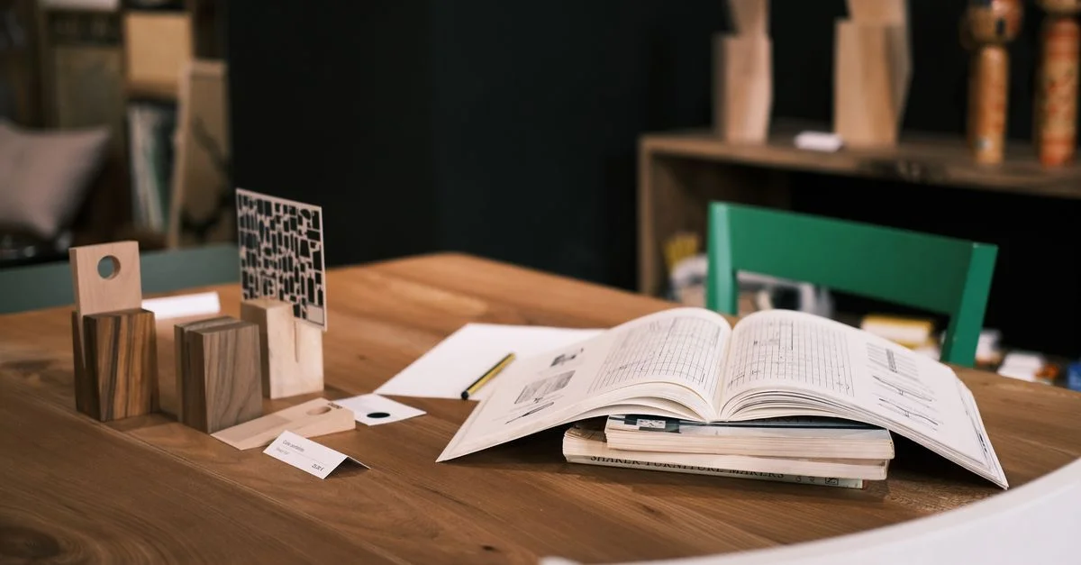 Bureau moderne et élégant avec livre ouvert, décor en bois et accents de design minimalistes pour un environnement de travail créatif.