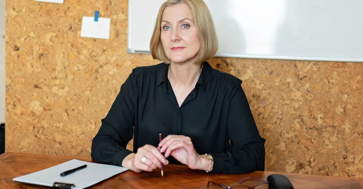 Femme d'affaires mature confiante assise à un bureau dans un environnement de bureau.