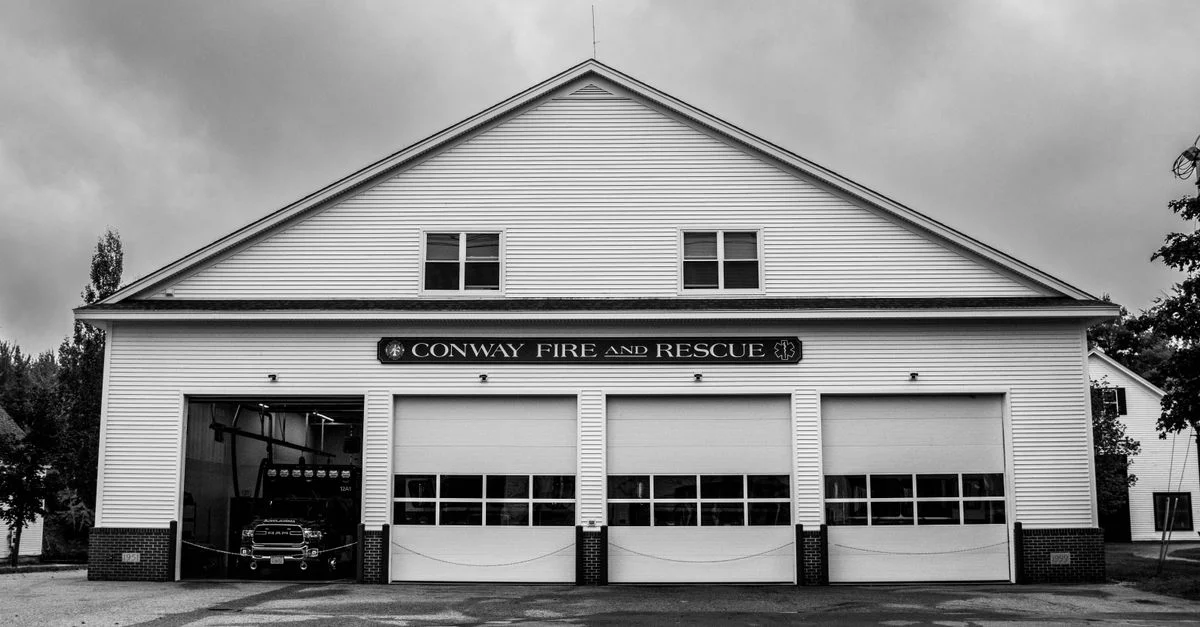 Photo en noir et blanc de l'extérieur de la caserne de pompiers et de secours de Conway mettant en valeur un design architectural classique.