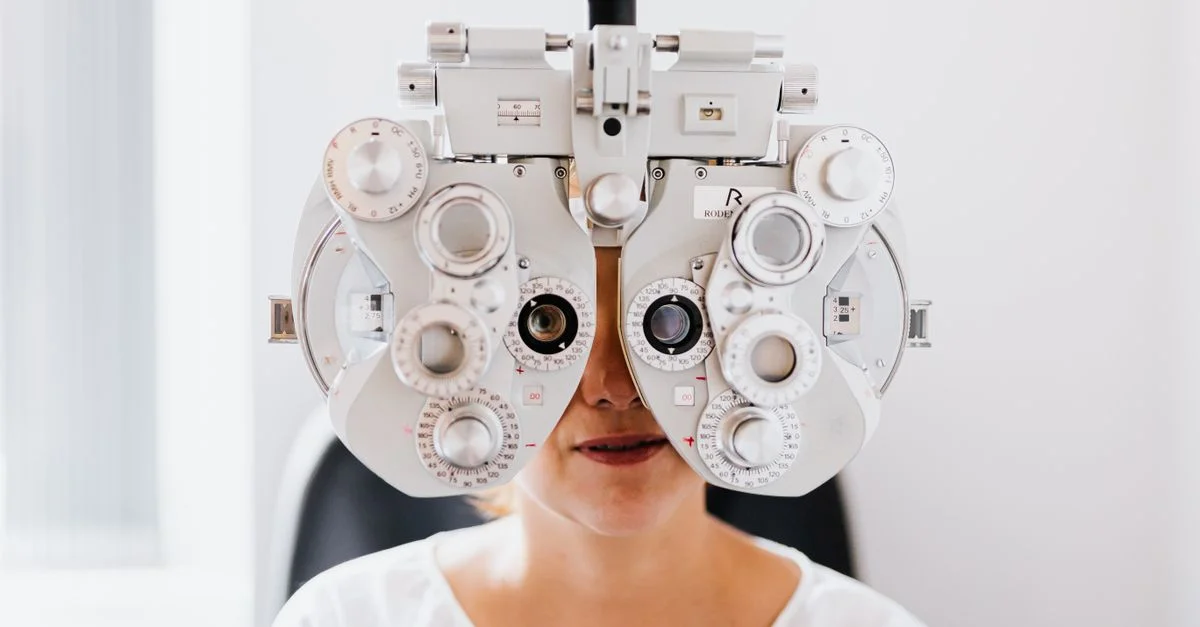 Vue détaillée d'une personne subissant un examen de la vue avec un phoroptère dans une clinique moderne.