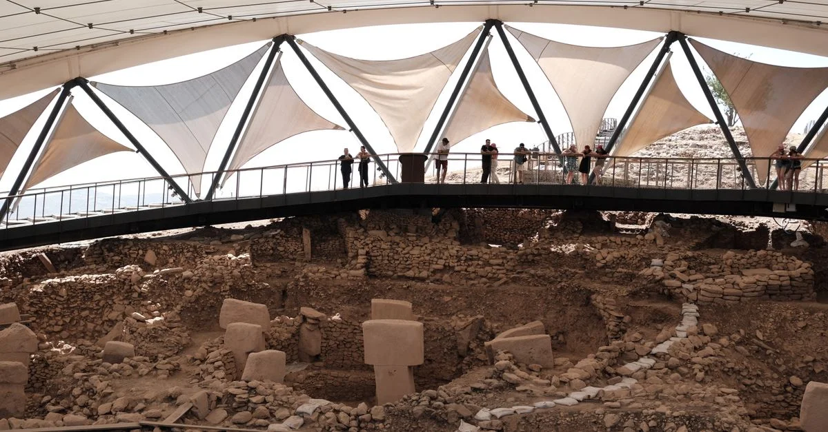 Les ruines archéologiques de Göbekli Tepe sous un auvent, sous le regard des touristes.