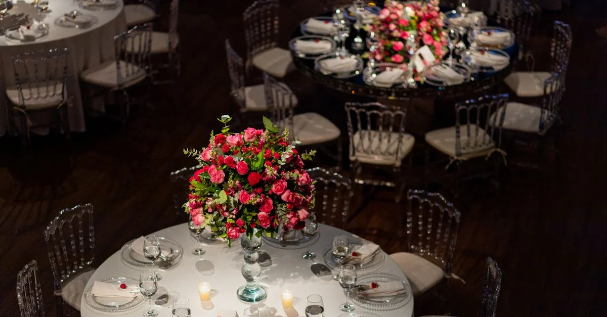 Tables de réception de mariage magnifiquement décorées avec des centres de table floraux et des bougies, créant une ambiance élégante.