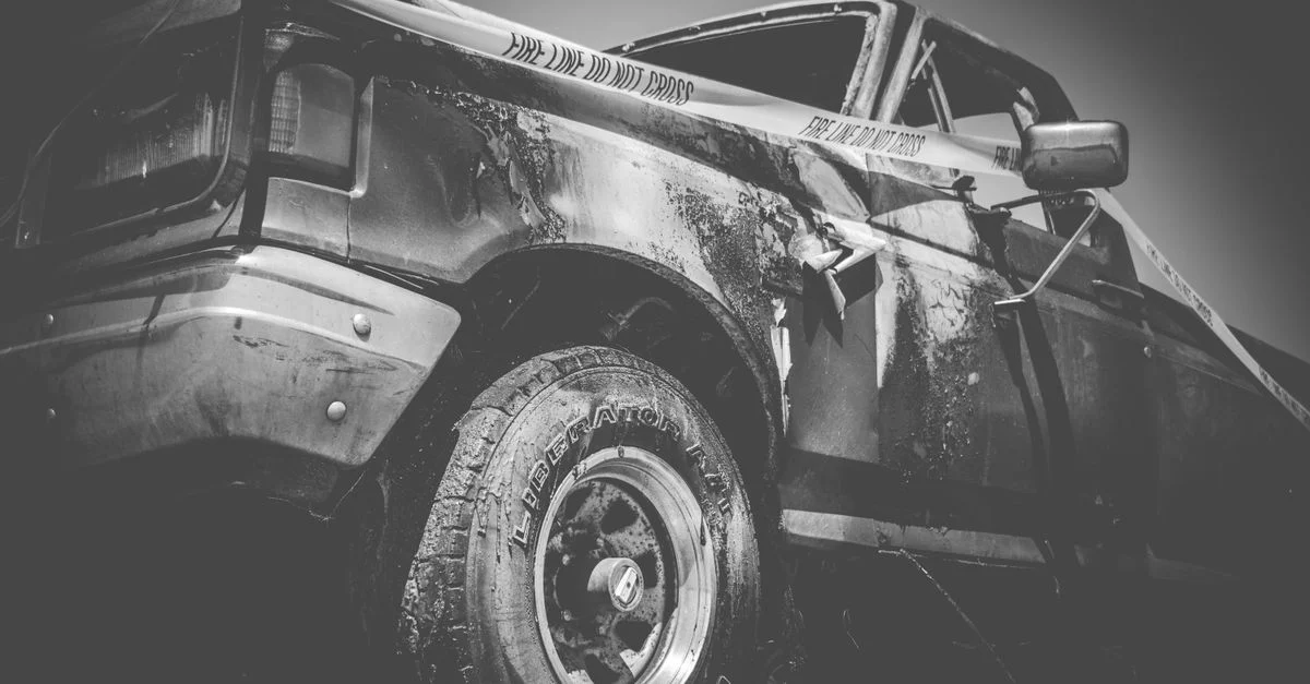 Image dramatique en noir et blanc d'un camion endommagé avec du ruban police.