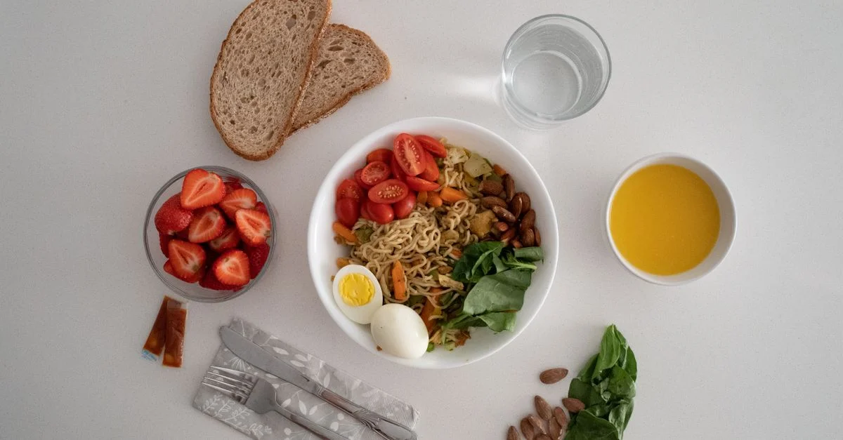Un repas équilibré composé d'une variété d'ingrédients sains, y compris des nouilles, des œufs, des amandes, des fraises et des légumes frais.