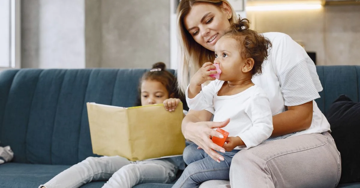 Mère et enfants partageant des moments tendres à la maison sur un canapé confortable.