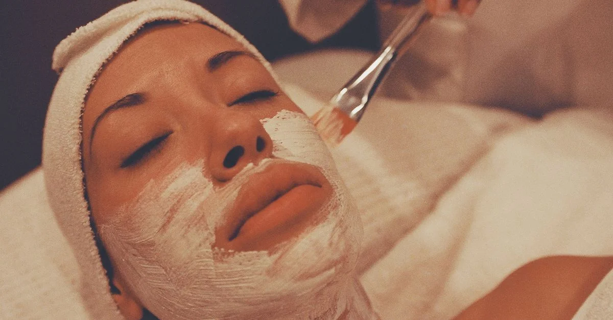 Une femme profite d'un soin du visage apaisant dans un spa, favorisant la détente et les soins de la peau.