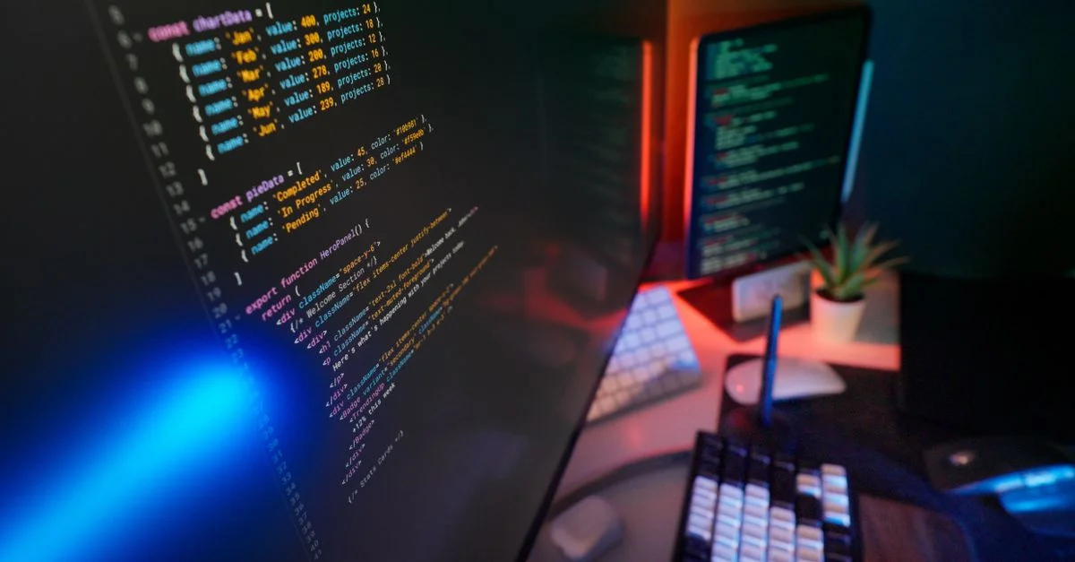 Un espace de travail dynamique avec du code coloré sur des écrans d'ordinateur, idéal pour les développeurs.