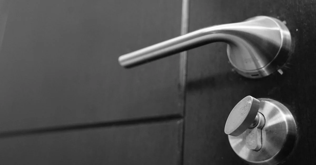 Photo en noir et blanc d'une poignée de porte en acier inoxydable élégante, mettant l'accent sur le style et la sécurité.
