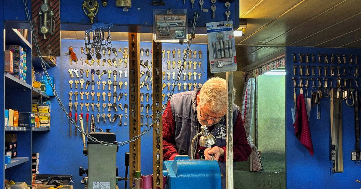 Un serrurier expérimenté fabrique une clé dans sa quincaillerie remplie de serrures et de clés.