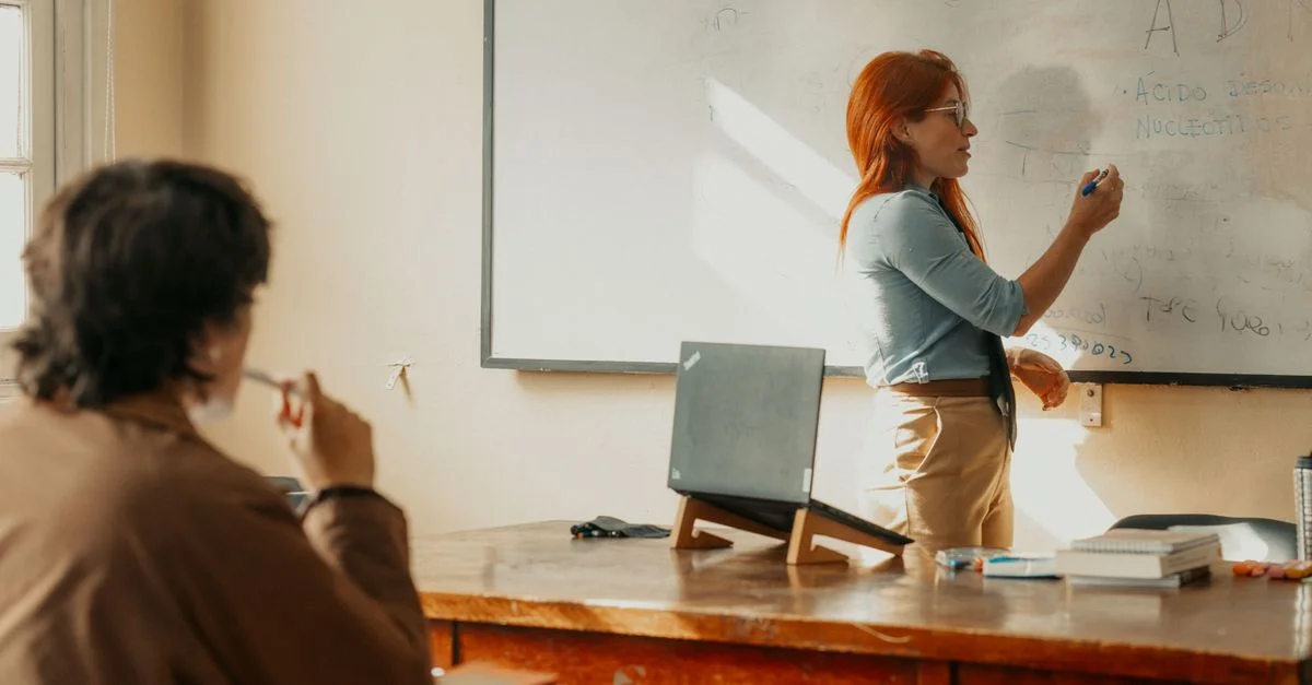 Un instructeur enseignant à un étudiant dans une salle de classe à Buenos Aires avec un tableau blanc.