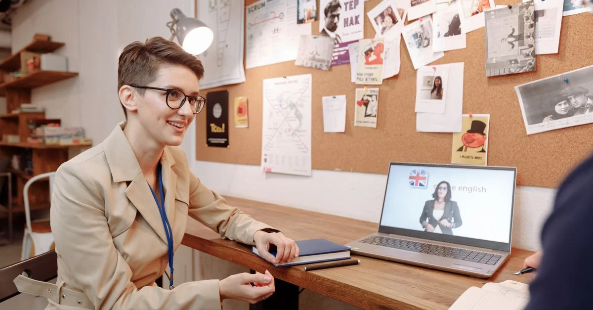 Une femme participant à une session de cours d'anglais en ligne dans un cadre éducatif moderne.