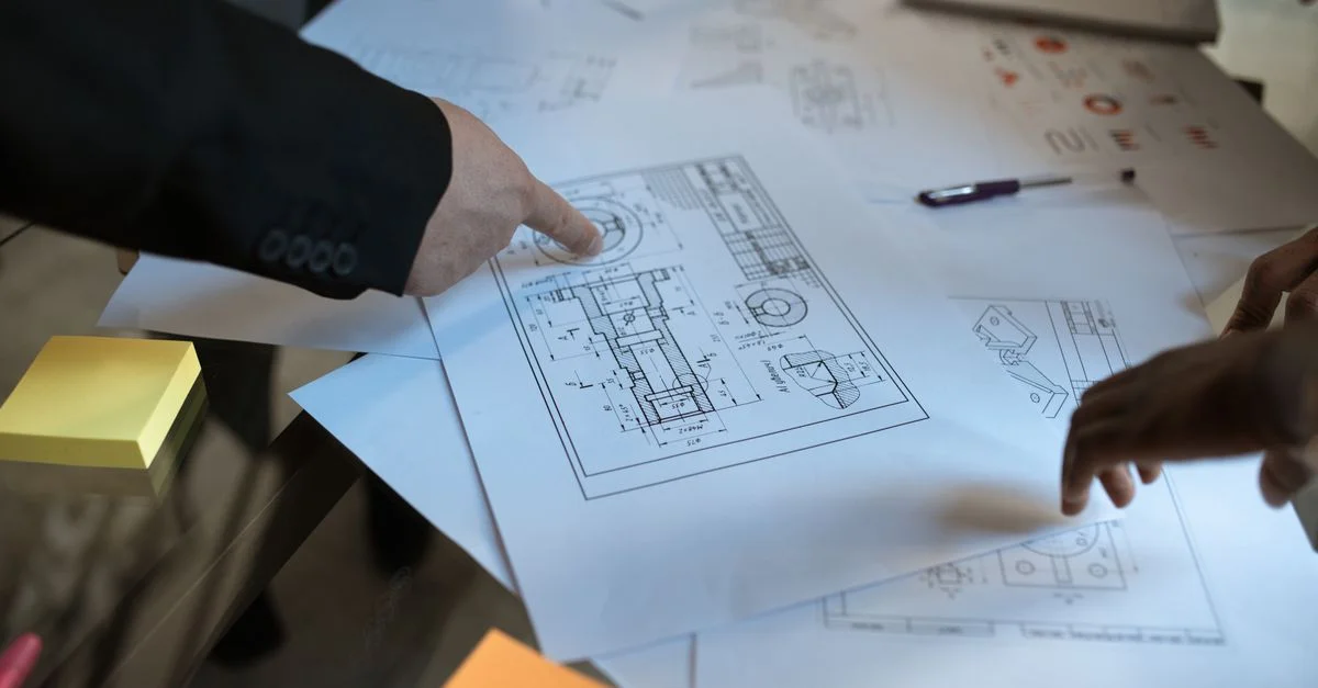 Des ingénieurs discutent de plans en blueprint dans un espace de travail, se concentrant sur le travail d'équipe et le design architectural.