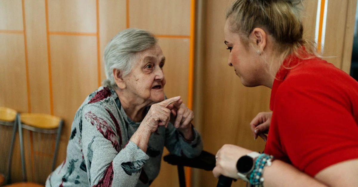 Femme âgée et assistante en conversation dans une pièce à Karviná, République tchèque.